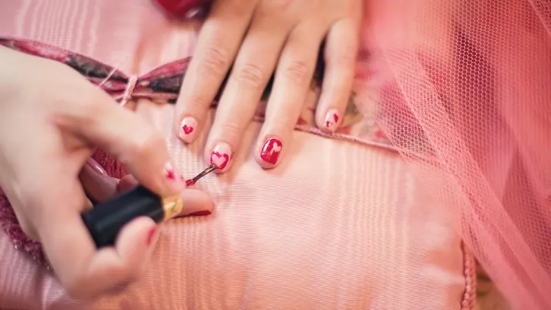 Uñas rojas con corazones pintados a mano